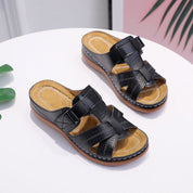 Sandali da donna in pelle nera con suola in gomma, design intrecciato, tacco basso. Scarpe estive eleganti e comode per uso quotidiano.
