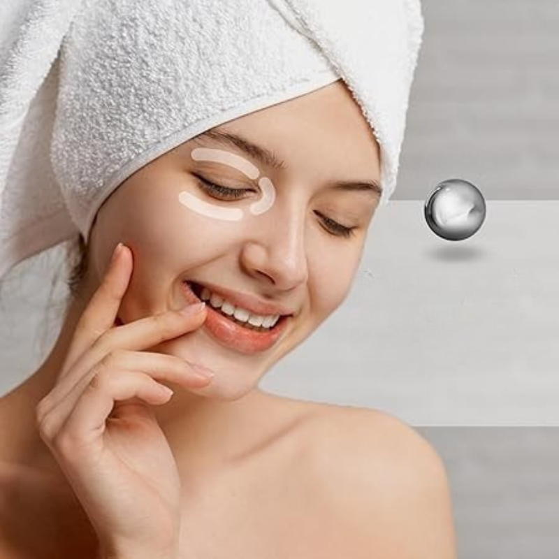 Donna sorridente con asciugamano bianco in testa applica crema contorno occhi. Skincare, bellezza, cura della pelle, trattamento viso.