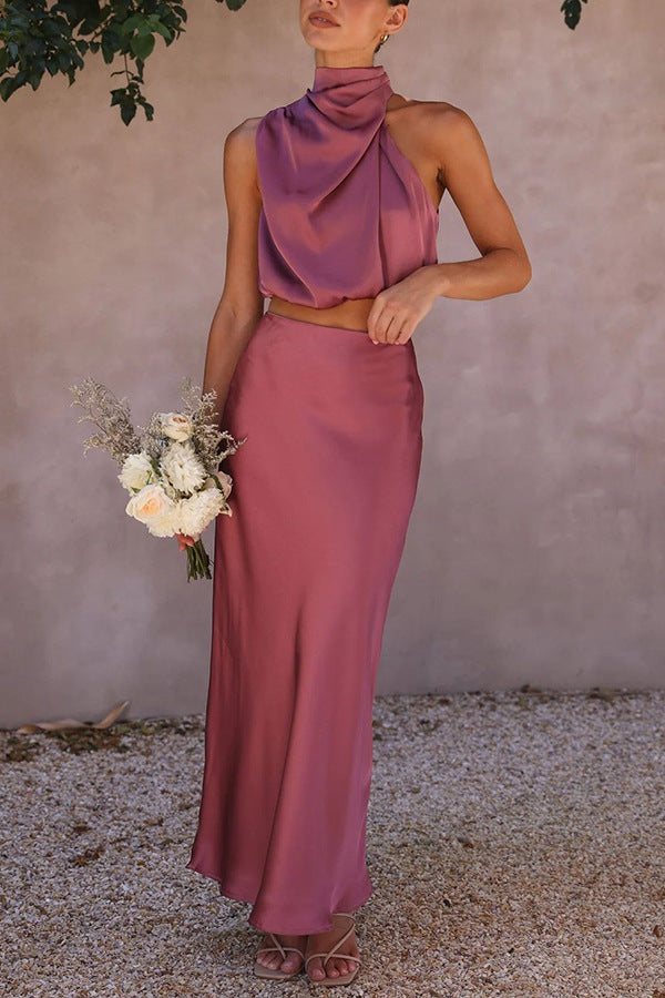 Abito da cerimonia elegante in raso rosa, top senza maniche e gonna lunga, bouquet di fiori bianchi, moda donna, abbigliamento formale.