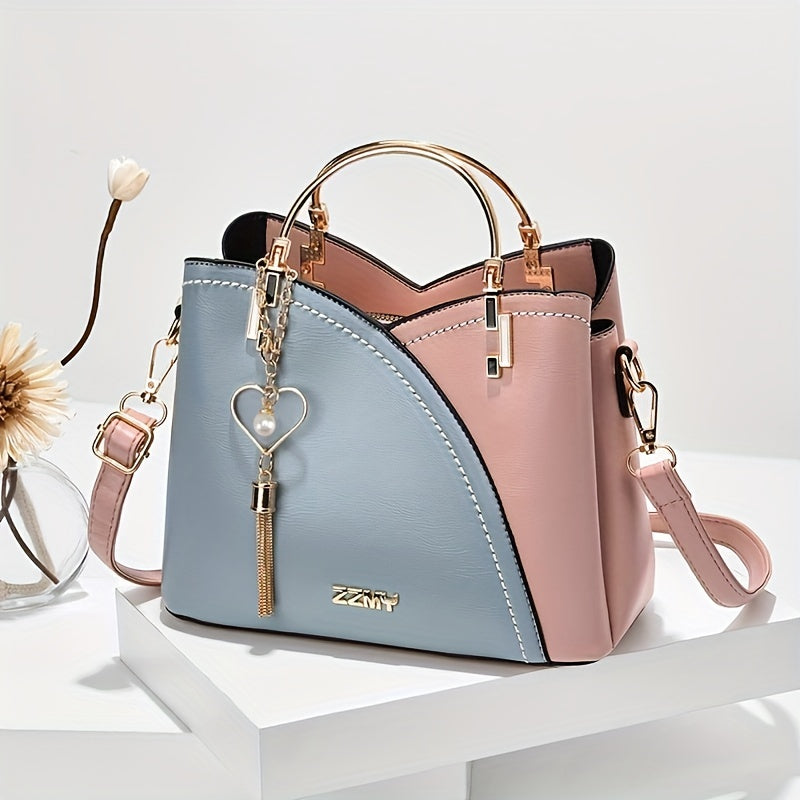 Borsa a mano in pelle bicolore rosa e blu con manico dorato e ciondolo a cuore, design elegante e moderno, perfetta per ogni occasione.