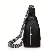 Zaino in pelle nera con tracolla regolabile a motivo geometrico bianco e nero, tasca frontale con zip, design moderno ed elegante.