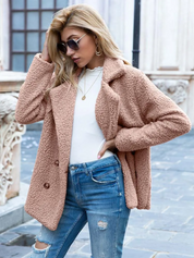 Donna con cappotto teddy marrone chiaro, occhiali da sole, jeans strappati e maglia bianca. Moda autunnale, stile casual chic, abbigliamento femminile.