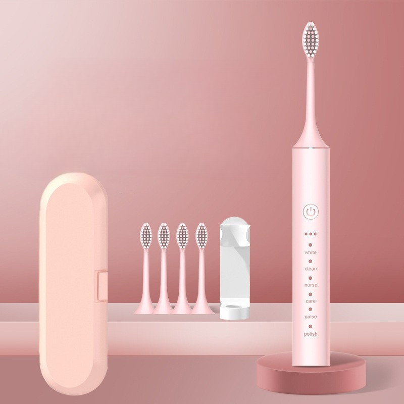 Spazzolino elettrico rosa con testine di ricambio, custodia da viaggio e caricatore. Design elegante, ideale per igiene orale quotidiana.
