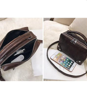 Borsa a tracolla in pelle marrone con zip, design compatto, ideale per smartphone e accessori. Elegante e pratica per l'uso quotidiano.