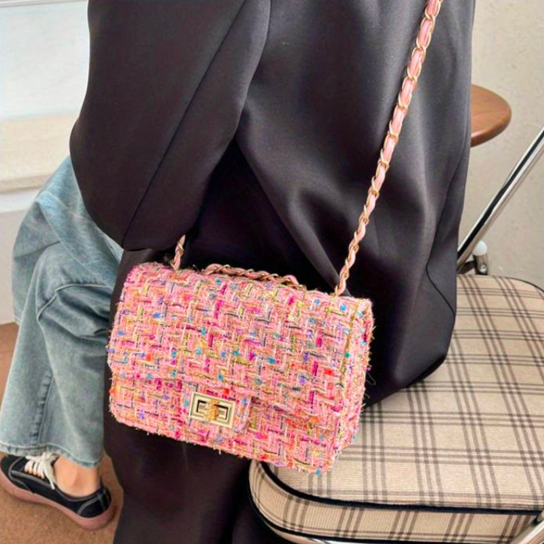 Borsa a tracolla in tweed multicolore su sfondo nero, design elegante, chiusura a scatto, perfetta per moda donna, accessorio chic e moderno.
