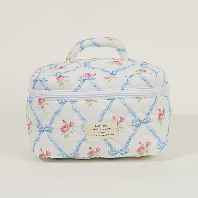 Borsa cosmetica trapuntata bianca con motivo floreale rosa e blu, manico superiore, chiusura a zip. Ideale per viaggi e organizzazione trucco.