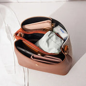 Borsa a tracolla in pelle marrone aperta, con portafogli, pochette e accessori interni. Design elegante, ideale per moda femminile e organizzazione.