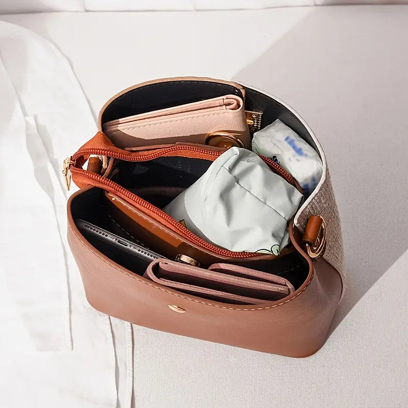 Borsa a tracolla in pelle marrone aperta, con portafogli, pochette e accessori interni. Design elegante, ideale per moda femminile e organizzazione.