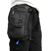 Marsupio nero in pelle, indossato su pantaloni neri, con tasche multiple e cerniera. Accessorio moda unisex, pratico per viaggi e attività all'aperto.