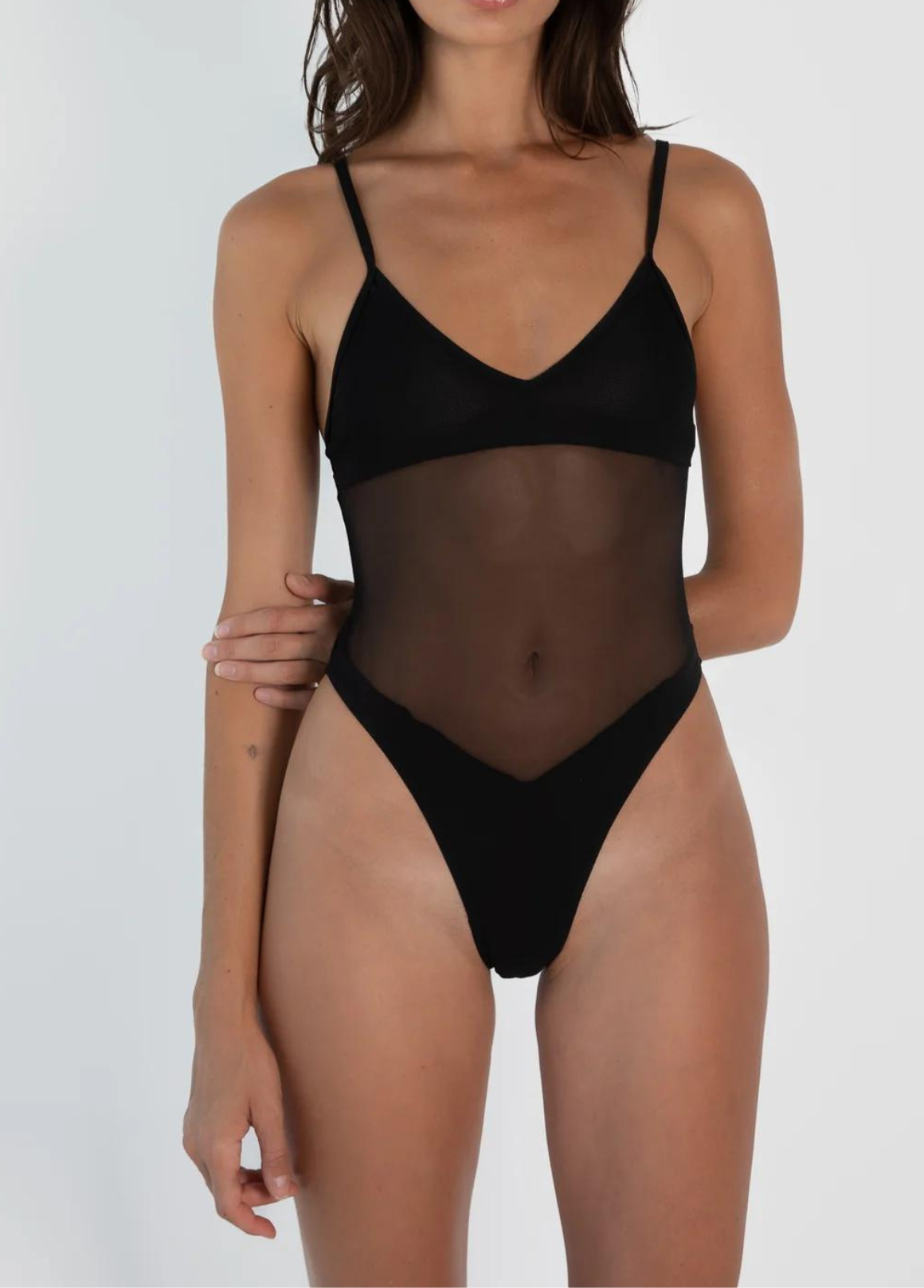 Donna in body nero trasparente, spalline sottili, design elegante. Intimo femminile moderno, moda donna, abbigliamento sexy.