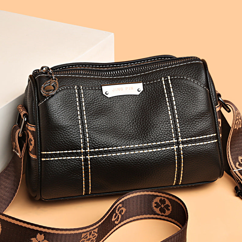 Borsa a tracolla in pelle nera con cuciture bianche, cerniera superiore e tracolla regolabile marrone. Design elegante e moderno per donna.