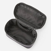 Astuccio da viaggio nero aperto, con scomparti interni in rete. Ideale per organizzare accessori e articoli da toeletta. Design compatto e funzionale.