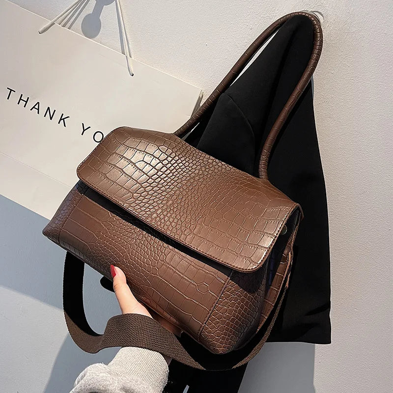 Borsa a tracolla in pelle marrone con texture coccodrillo, design elegante e moderno, perfetta per moda donna. Accessorio chic e versatile.