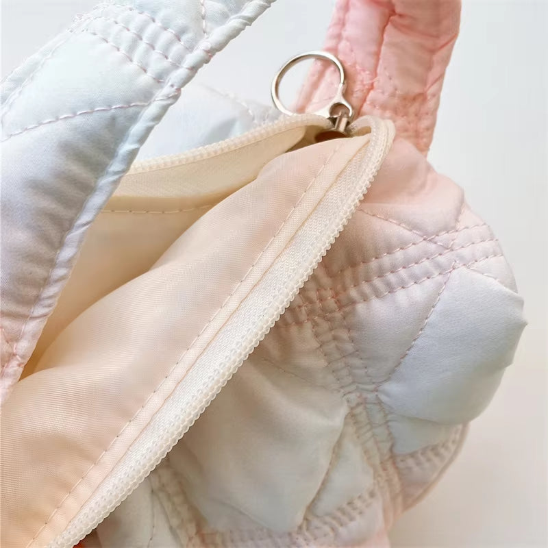 Zaino trapuntato rosa e bianco con cerniera in metallo, design elegante e moderno, ideale per moda femminile e accessori di tendenza.