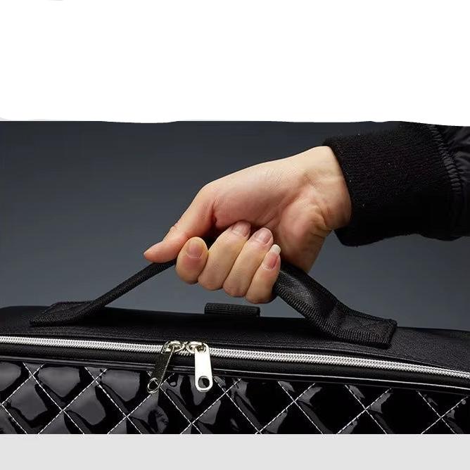 Mano che tiene una borsa nera trapuntata con cerniera, design elegante e moderno. Accessorio moda, borsa a mano, stile sofisticato.