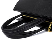 Borsa a mano in pelle nera con manici eleganti e cerniera dorata, design moderno e raffinato, accessorio moda donna di alta qualità.
