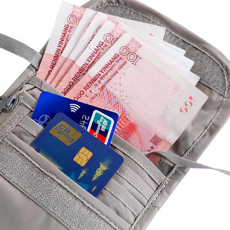 Portafoglio grigio con tasche multiple contenente banconote cinesi e carte di credito. Accessorio da viaggio sicuro e organizzato.