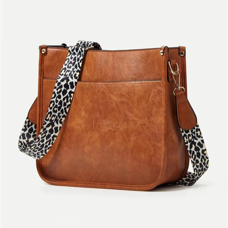 Borsa a tracolla in pelle marrone con cinturino leopardato, design elegante e moderno, perfetta per moda donna e accessori di tendenza.