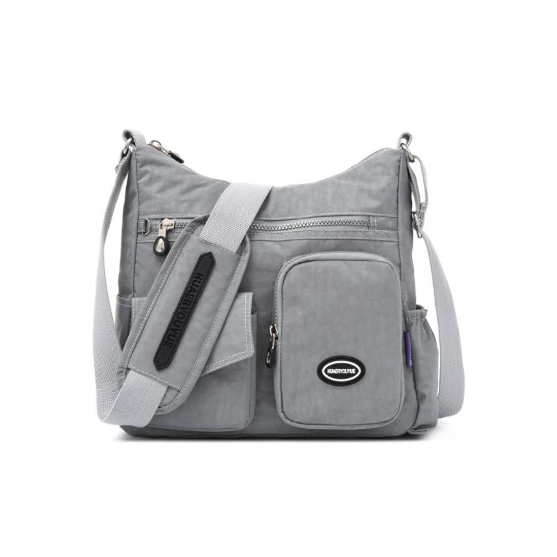 Borsa a tracolla grigia in nylon impermeabile con tasche multiple e cerniere, ideale per viaggi e uso quotidiano. Design pratico e resistente.