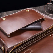 Borsa in pelle marrone con tasca aperta, portafoglio nero visibile. Elegante accessorio moda, ideale per lavoro e viaggi.