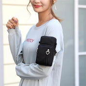 Donna con custodia da braccio nera per smartphone, indossata su maglia grigia. Accessorio sportivo pratico per corsa e attività all'aperto.