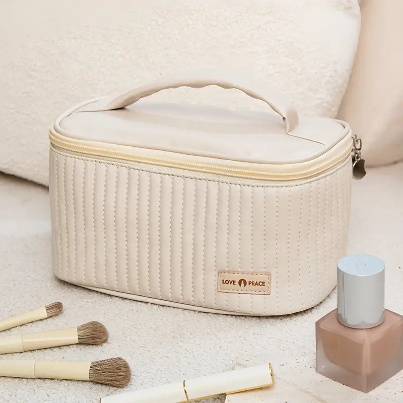 Borsa cosmetica beige con manico, design trapuntato, zip, pennelli trucco e smalto. Ideale per organizzare prodotti di bellezza.
