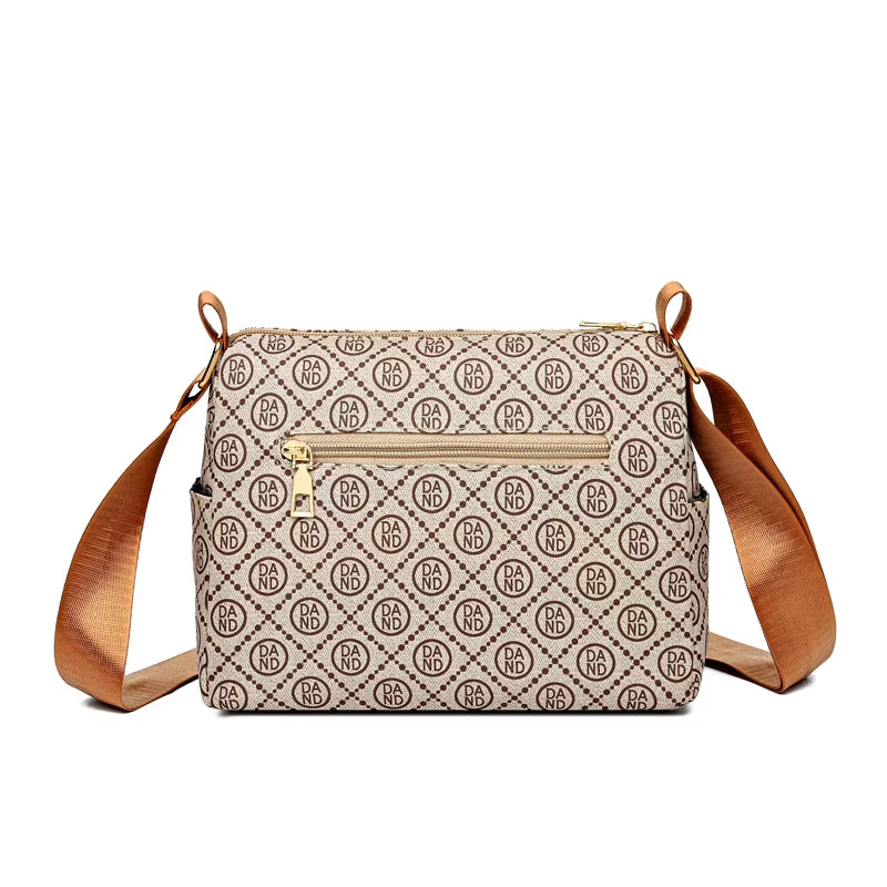 Borsa a tracolla beige con motivo monogramma, tasca frontale con zip, dettagli in pelle marrone, ideale per moda donna e accessori eleganti.