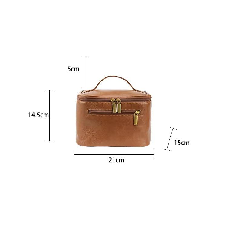 Borsa cosmetica in pelle marrone con manico, cerniera dorata, dimensioni 21x15x14,5 cm. Elegante e pratica per viaggi e organizzazione.