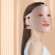 Donna con maschera LED per terapia della pelle, design elegante, colore rosa, utilizzata per trattamenti anti-età e cura del viso, sfondo beige.