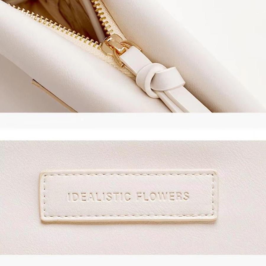 Borsa bianca in pelle con cerniera dorata e logo "Idealistic Flowers". Elegante accessorio moda, perfetto per look sofisticati e moderni.