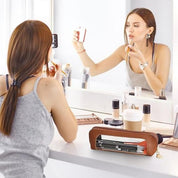Donna che si trucca davanti a uno specchio, con astuccio in pelle per trucchi in primo piano. Accessori make-up, routine bellezza, cosmetici.