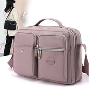 Borsa a tracolla in pelle sintetica rosa con tasche multiple e cerniere, design elegante e pratico per donna, ideale per uso quotidiano e viaggi.