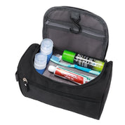 Borsa da toilette nera aperta con gancio, contenente flaconi da viaggio, dentifricio, spazzolino e deodorante. Ideale per viaggi e organizzazione.