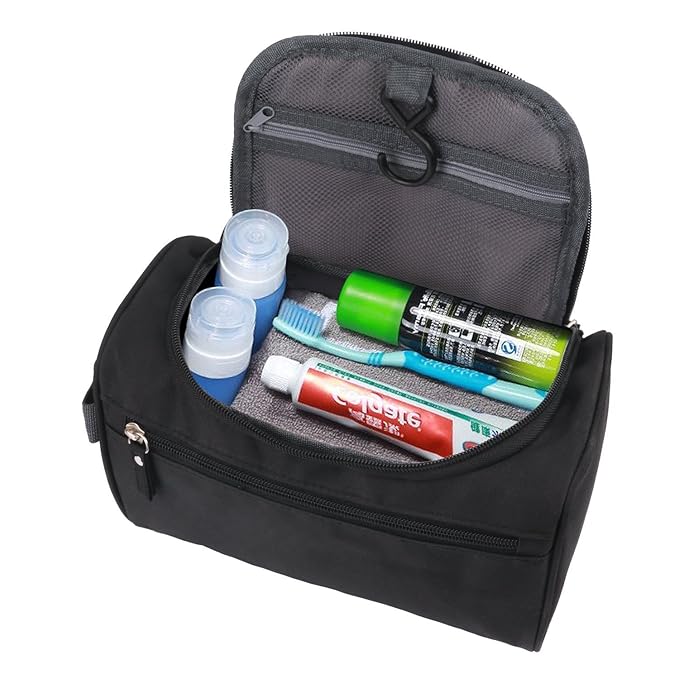 Borsa da toilette nera aperta con gancio, contenente flaconi da viaggio, dentifricio, spazzolino e deodorante. Ideale per viaggi e organizzazione.