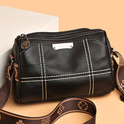 Borsa a tracolla in pelle nera con cuciture bianche, design elegante, cinturino regolabile marrone, ideale per moda donna, accessori di tendenza.