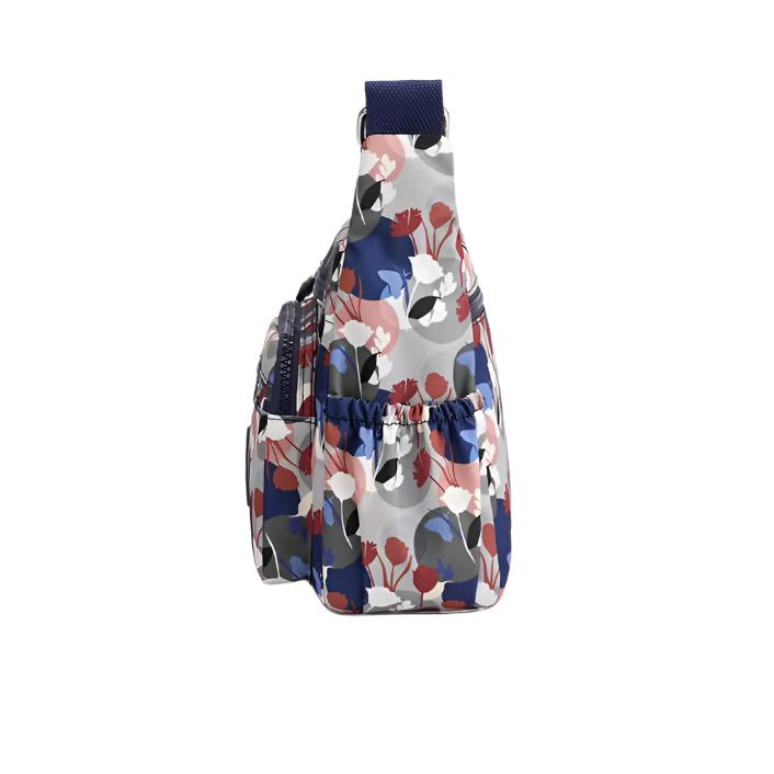 Zaino monospalla floreale multicolore, tasche laterali elastiche, design moderno, ideale per moda donna, accessori viaggio, stile casual.