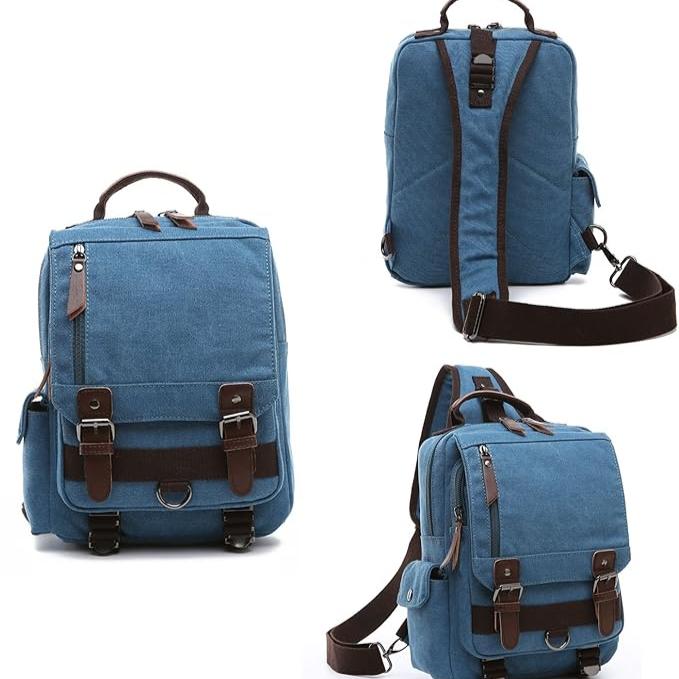 Zaino in tela blu con dettagli in pelle marrone, tasche multiple, cinghie regolabili. Design versatile per scuola, lavoro, viaggi.