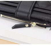 Portafoglio in pelle nera con cerniera dorata, design elegante e moderno, accessorio moda donna, ideale per organizzare carte e contanti.