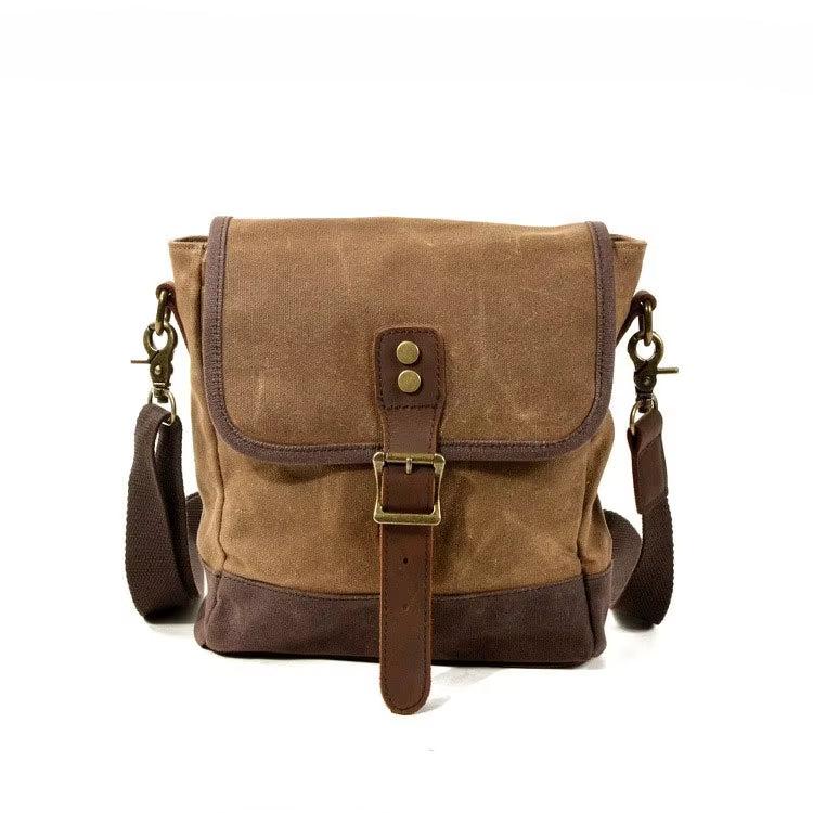 Borsa a tracolla in tela cerata marrone con dettagli in pelle, fibbia frontale e tracolla regolabile. Stile vintage, ideale per uomo e donna.