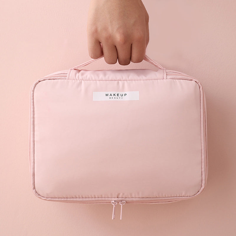 Borsa trucco rosa con manico, chiusura a zip, design compatto. Ideale per organizzare cosmetici e accessori di bellezza.