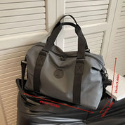 Borsa da viaggio grigia con manici neri, dimensioni 41x24x16 cm, su sedia. Design elegante, ideale per viaggi e uso quotidiano.