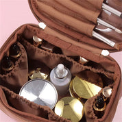 Borsa cosmetica marrone con scomparti, contenente flaconi e pennelli trucco. Organizzatore da viaggio per cosmetici, accessori bellezza.