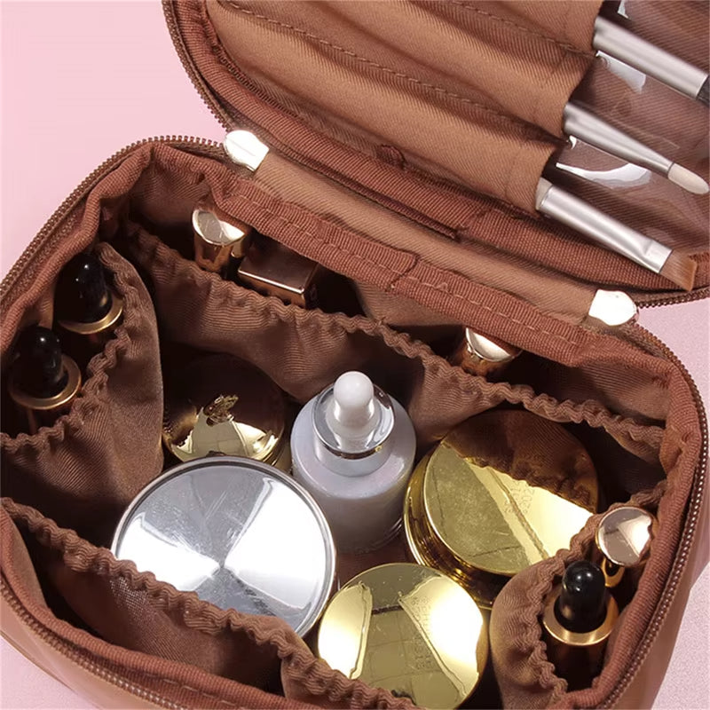 Borsa cosmetica marrone con scomparti, contenente flaconi e pennelli trucco. Organizzatore da viaggio per cosmetici, accessori bellezza.