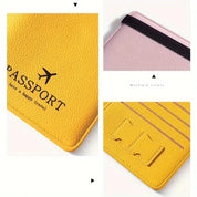 Custodia passaporto in pelle gialla con scritta "Have a happy travel", elastico nero, tasche interne. Disponibile in vari colori. Accessorio viaggio elegante.