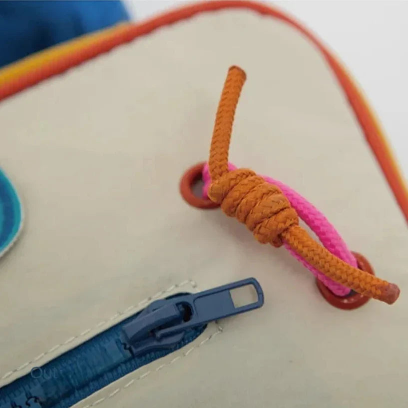 Zaino colorato con cerniera blu e cordino arancione, dettagli vivaci. Accessorio moda, resistente e pratico per scuola o viaggio.