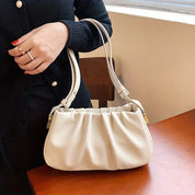 Borsa a spalla bianca in pelle, design elegante con manici doppi, indossata da una donna. Accessorio moda femminile, perfetto per ogni occasione.