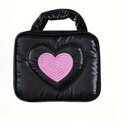 Borsa a mano nera con cuore rosa centrale, design moderno, materiale imbottito, ideale per moda femminile, accessorio trendy e versatile.