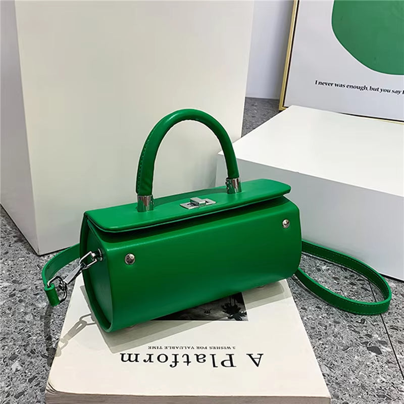 Borsa a mano verde elegante con tracolla, design moderno, chiusura a scatto, su sfondo minimalista. Accessorio moda donna, stile contemporaneo.