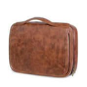 Borsa da viaggio in pelle marrone con manico, design elegante e spazioso, ideale per organizzare accessori e articoli da toeletta.