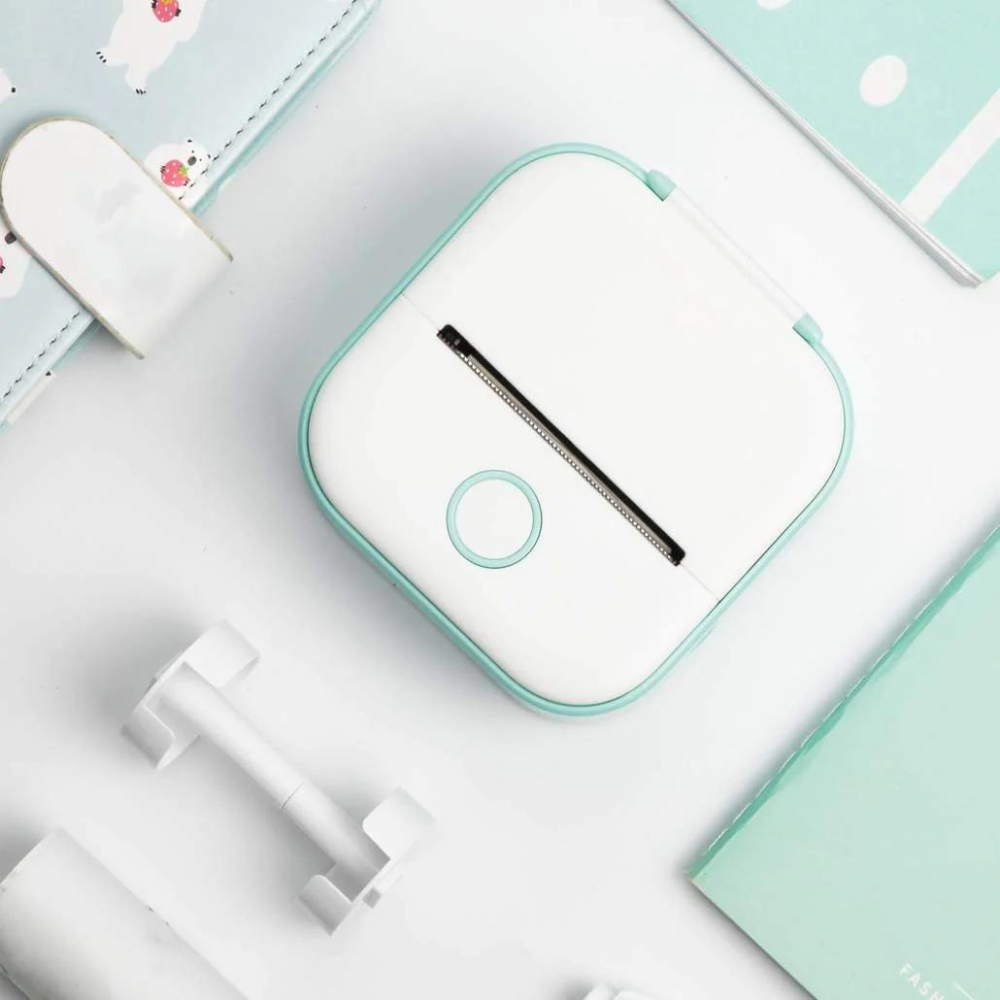Stampante termica portatile bianca e azzurra su sfondo bianco, ideale per etichette e foto. Design compatto, perfetta per ufficio e casa.